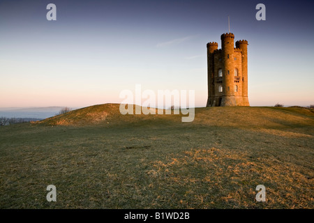 Very famous Broadway Tower overlooking the pituresque village of Broadway.  Early morning with sunrise behind. Stock Photo