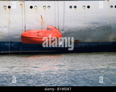 offshore rescue vessel lifeboat hanging on the side of a large ship for maintenance Antwerp port Belgium Stock Photo
