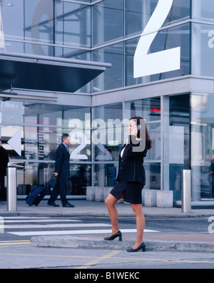 woman on mobile phone at airport terminal Stock Photo