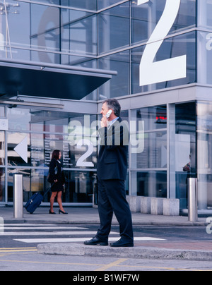 man on mobile phone at airport terminal Stock Photo
