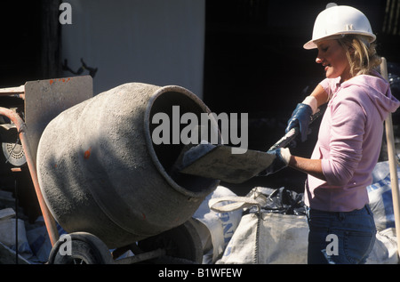 female builder mixing cement Stock Photo