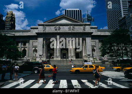 USA North America Manhattan New York City Public Library exterior with pedestrians crossing and yellow taxi cabs in foreground Stock Photo