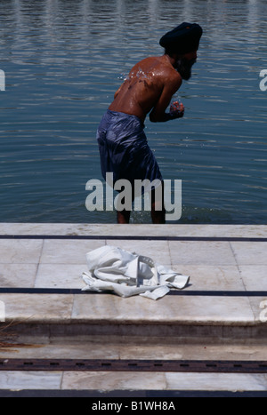 INDIA Uttar Pradesh Delhi Sikh man washing himself in temple pool water whilst wearing kachs. Stock Photo