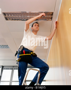 electrician repairing light fitting Stock Photo