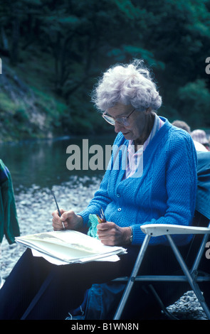 elderly woman outside painting watercolours Stock Photo