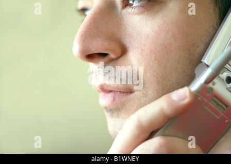 Portrait of a young man on his cell phone He is listening with a serious look of concern on his face Stock Photo