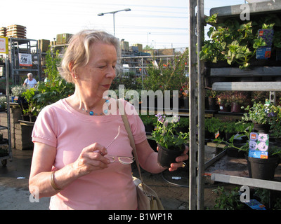 elderly woman buying plants from nursery Stock Photo