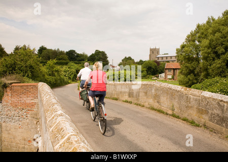 Two cyclists on a bridge near Wiveton in Norfolk Stock Photo