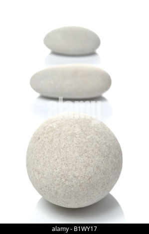 Three white pebbles focus on front pebble isolated on a white background Stock Photo