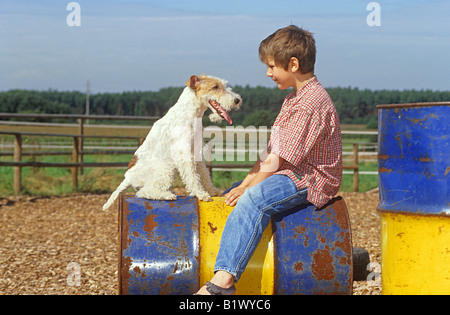 boy and foxterrier - sitting on barrel Stock Photo