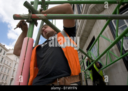 Two workers construct scaffolding. Stock Photo