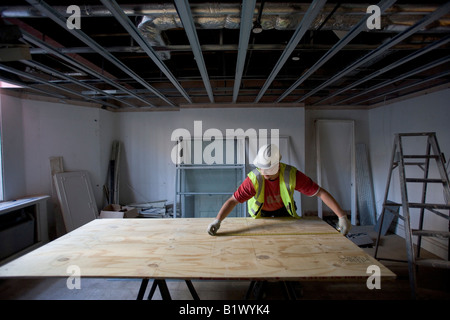 A worker measures a piece of wood. Stock Photo