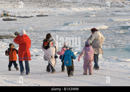 Inuit women walking with children them in Grise Fiord, Nunavut, Canada. North America's Furthest Northern Community Stock Photo