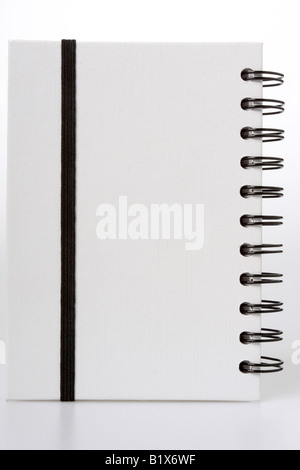 White notebook with black ring binders isolated on white black string to hold it closed Stock Photo