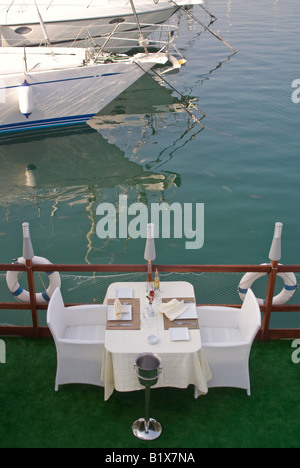 Vertical elevated view of an empty table for two set outside ready for dinner service at an expensive waterside restaurant Stock Photo