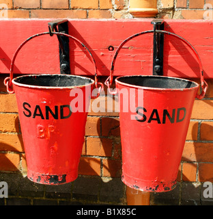 British Railways old antique red fire fighting buckets containing sand Stock Photo