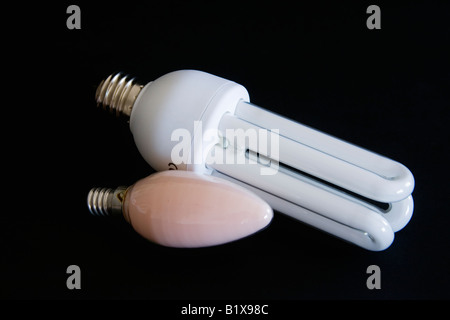One energy saving light bulb and one traditional candle light bulb on black background Stock Photo