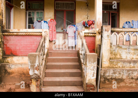 Washed clothes hanged outside on the veranda of an old deteriorated villa in Maputo, Mozambique. Stock Photo