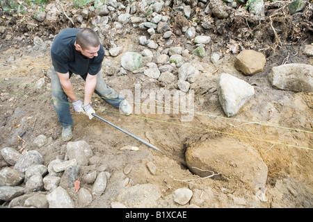 Man building stone fence Stock Photo
