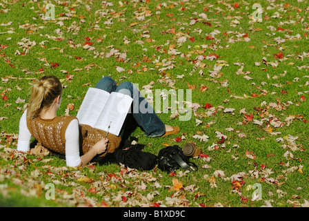 Canada, Montreal, McGill University, woman student reading on lawn Stock Photo
