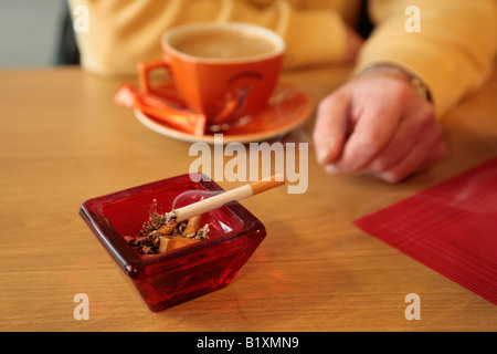 a burning cigarette in an ash tray at restaurant Stock Photo