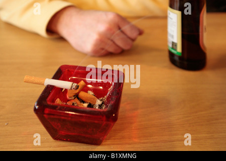 a burning cigarette in an ash tray at restaurant Stock Photo