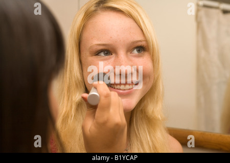 two teenage girls doing each other's hair and makeup Stock Photo