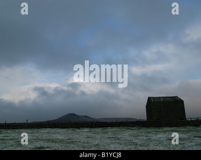 A bleak, frosty and cloudy landscape looking out over hills and farm land in northern England.