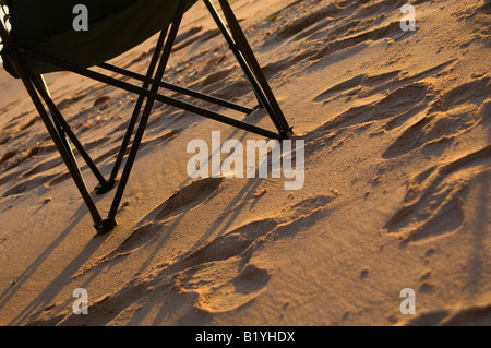 Folding chair on beach, sand and shadow Stock Photo