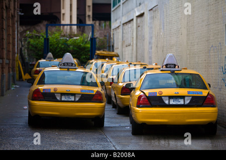 NYC Yellow taxi cabs parked in the alley between buildings Queens NY USA Stock Photo