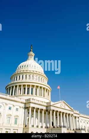 United States Capitol Building Dome Washington DC | WASHINGTON D.C., United States — A vertical view of the U.S. Capitol's dome and east portico frames the building against open sky, with the Statue of Freedom at its apex. Thomas U. Walter's cast-iron design, completed in 1866, replaced Charles Bulfinch's earlier wooden dome after the Capitol's 1850s expansion made the original look disproportionate. Stock Photo