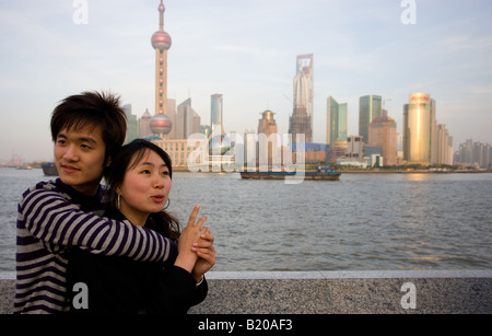 Young couple pose by the Pudong Financial District skyline at the Bund Shanghai China Stock Photo