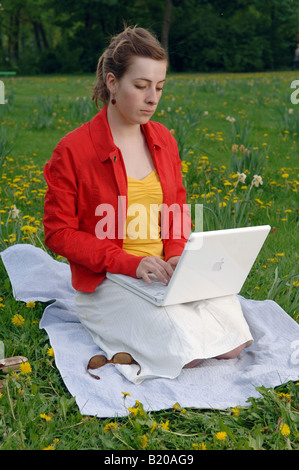 Young woman working on her laptop in a park Stock Photo