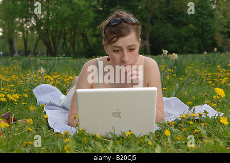 Young woman working on her laptop in a park Stock Photo