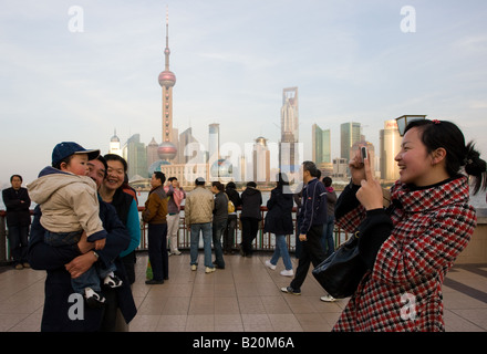 Tourists at the Bund to view the Pudong Financial District skyline Shanghai China Stock Photo