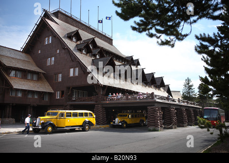 A restored vintage Yellowstone Park tour bus in front of Old Faithful Inn Stock Photo