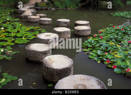 Stepping stones lead across a garden lily pond at the Heian Jungu shrine in Kyoto. Stock Photo