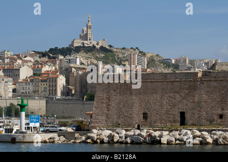 View of Marseilles harbour looking from the harbour entrance back towards Notre Dame de la Garde Cathedral on the hill. Stock Photo