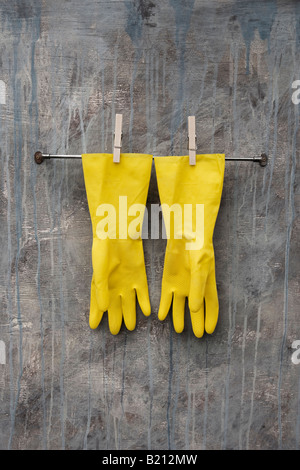 Yellow rubber gloves pegged up Stock Photo