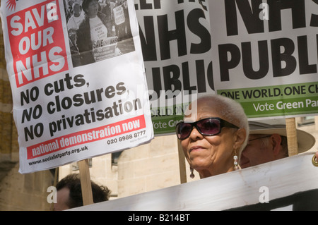 Black woman and placards at London Keep our NHS Public demo on 60th anniversary of NHS outside Richmond House, Whitehall NHS HQ Stock Photo