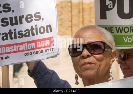 Black woman and placards at London Keep our NHS Public demo on 60th anniversary of NHS outside Richmond House, Whitehall NHS HQ Stock Photo