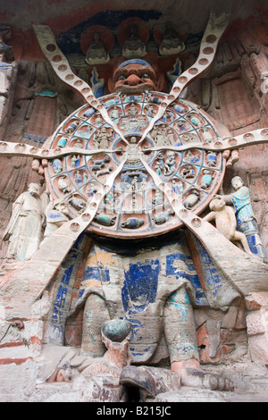 Anicca God of Destiny holds wheel of life of Buddhist karma Dazu rock carvings Mount Baoding China Stock Photo