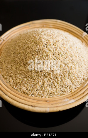 Bamboo basket of brown wholegrain rice Rice has become an expensive commodity as its in short supply Stock Photo
