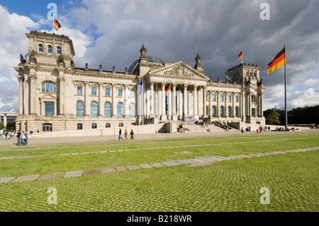 A wide angle view of the Reichstag (German Parliment Building) and tourists on a sunny day with dark clouds behind. Stock Photo