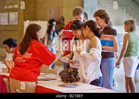 Seeking advice on which college to attend high school students and parents check in with a receptionist at a college fair in Los Stock Photo