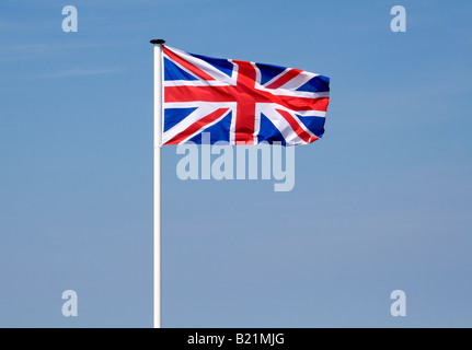 Union Jack flag on a white flagpole fluttering in the breeze. Stock Photo