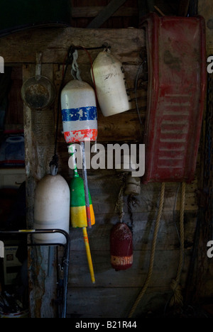 Old lobster trap buoys and bric-a-brac hang on the wall in the garage of a farm house built circa 1890, near Bristol, Maine Stock Photo