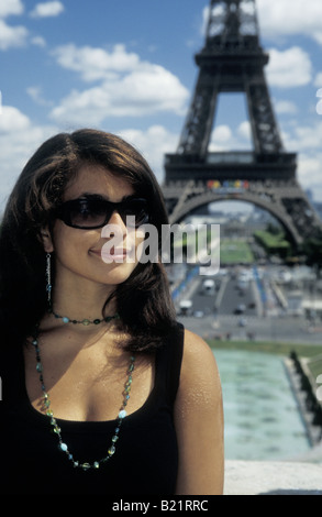glamorous young woman in sunglasses posing in front of Eiffel Tower Paris Stock Photo