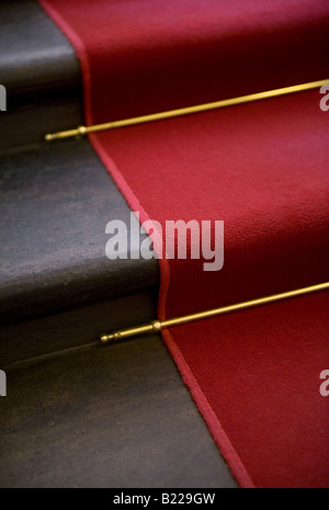 Red carpet, brass stair rods and staircase Stock Photo