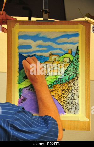 Painter inserting blue shadows onto mountains at an arts festival Stock Photo